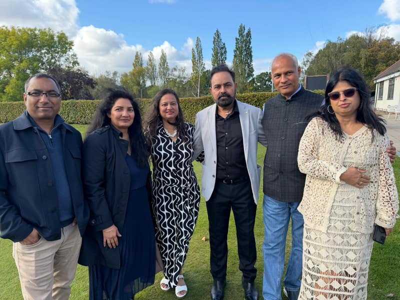 Six friends standing together on the lawn